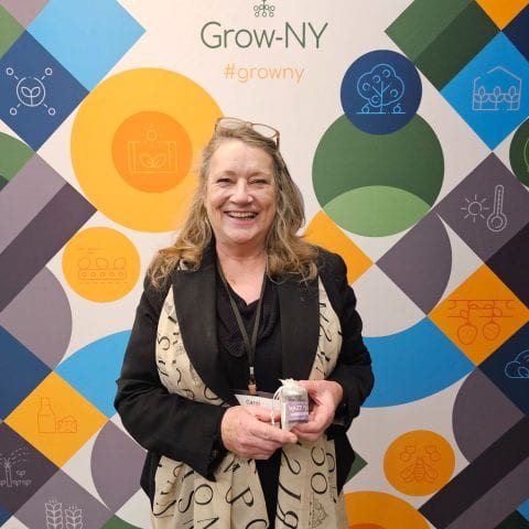 Image of Carol Fitzgerald in front of Grow-NY banner