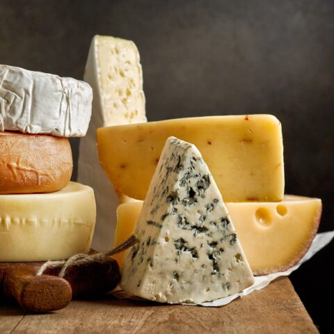 a variety of cheese blends displayed on a wooden table